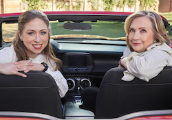 Hillary and Chelsea Clinton pose for a picture in a convertible car.