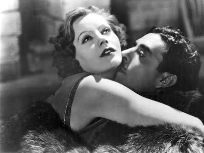 Greta Garbo and John Gilbert embracing.