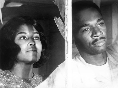 Abbey Lincoln and Ivan Dixon looking through a window.