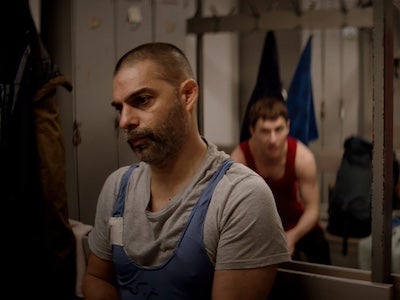 Two men in a wrestling locker room.