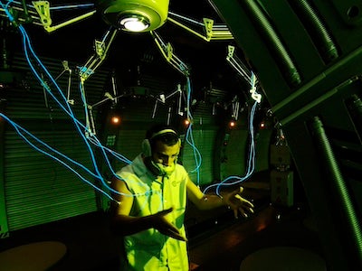 A man attached to a mechanical device by wires.