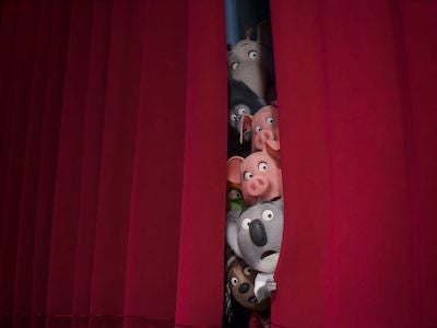 Animated animals looking through a theater curtain.