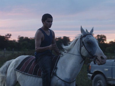 A young man riding a horse.