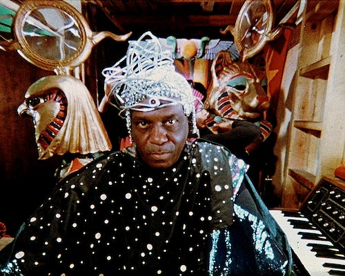 Sun Ra in a futuristic outfit, surrounded by ancient Egyptian symbols.