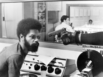 A man looking at a gun that is pointed to his face.