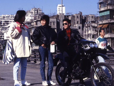 Three people talking in a city street.