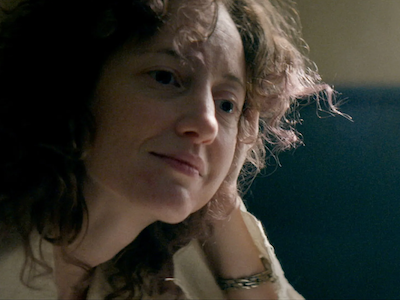 A woman resting her head on her hand.