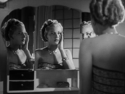 A woman looking at her reflection in a mirror.