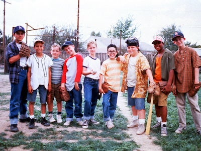 A row of boys wearing baseball gloves.