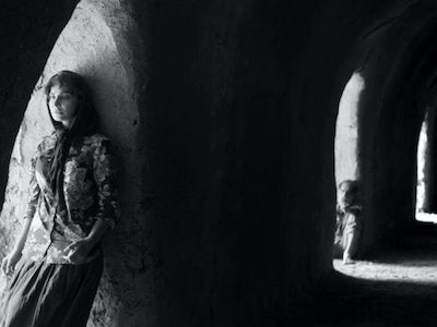 A woman and a man leaning on arches.
