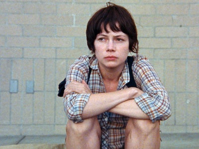 A woman sitting on a sidewalk.
