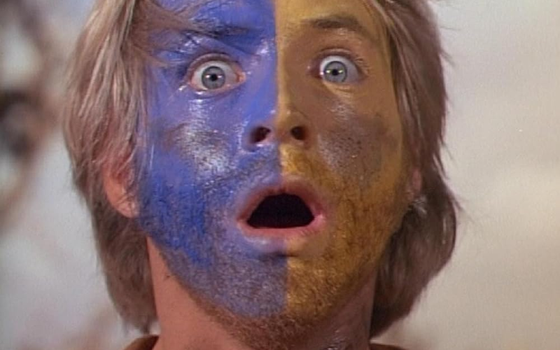 A stunned looking man with paint on his face.