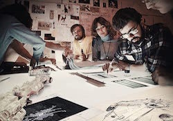 A young George Lucas and team review prop designs for Star Wars franchise on top of a light table