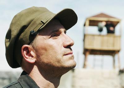 A man in a cap looking upward.