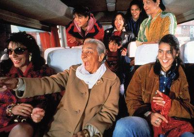 A group of women laughing and smiling on a bus.