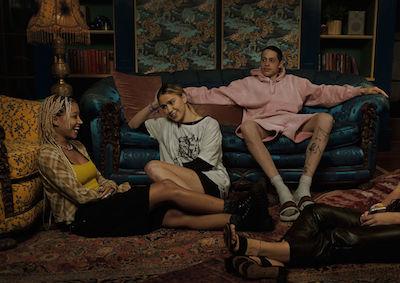 Three young people lounging in an ornate living room.