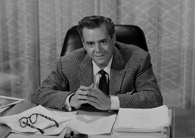 Desi Arnaz sitting at a desk