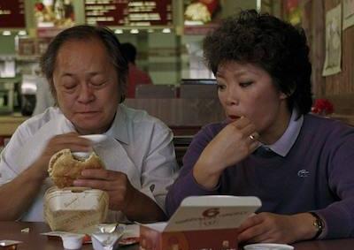 A man and a woman eating at a fast food restaurant.