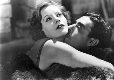 Greta Garbo and John Gilbert embracing.