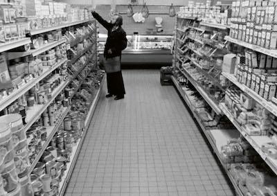 A man shopping in a grocery aisle.