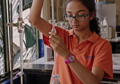 A student using science lab equipment.