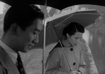 A man and a woman holding umbrellas.