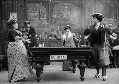 Women smoking and playing billiards.