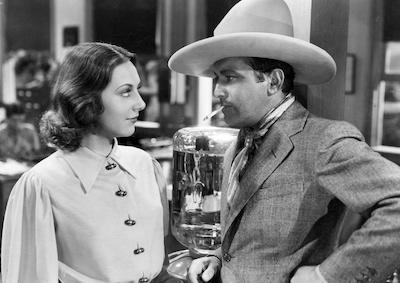 Actors Ann Dvorak and Richard Barthelmess looking at each other, in old Western clothing.