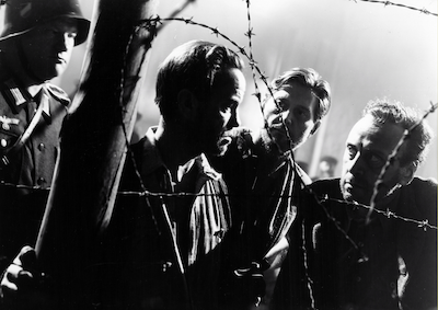 The Master Race Men behind barbed wire.