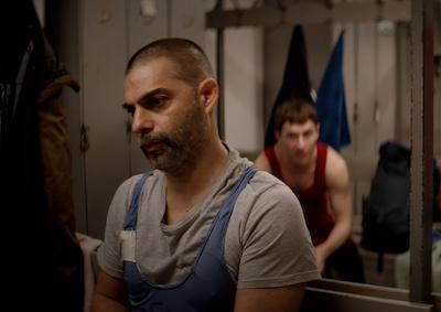 Two men in a wrestling locker room.