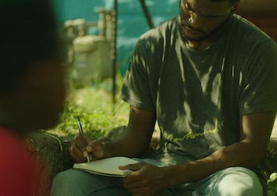 A man writing in a notebook.