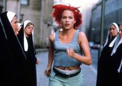 A woman running past a group of nuns.