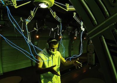 A man attached to a mechanical device by wires.