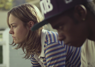 Actors Brie Larson and LaKeith Stanfield sitting side by side with serious expressions.