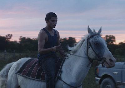 A young man riding a horse.