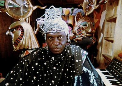 Sun Ra in a futuristic outfit, surrounded by ancient Egyptian symbols.