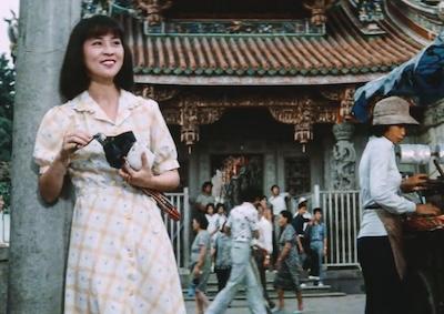 A woman smiling in front of a temple.