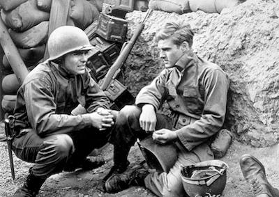 Two military men in a trench.