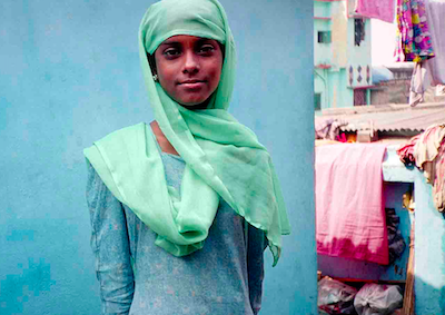 A girl wearing a scarf over her head.