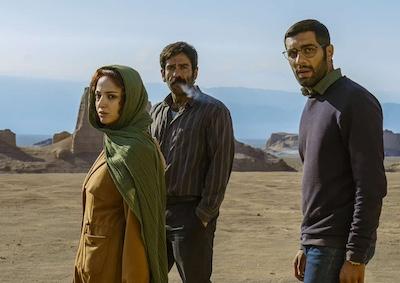 Three people standing in the desert.