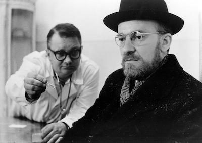 A doctor handing a small item to a man.