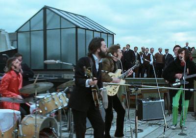 The Beatles performing on a roof.