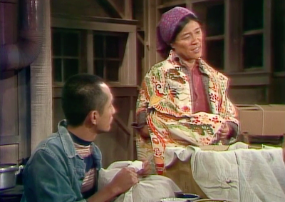 A Japanese American woman cloaked in a kimono as she packs her belongings with a family member.