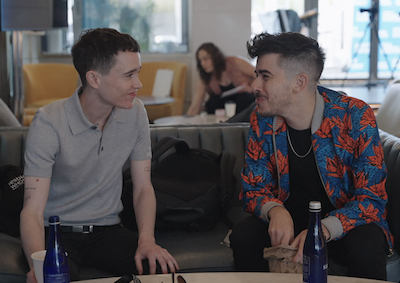 Elliott Page and Chase Strangio sitting together on a sofa.