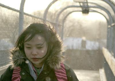 A girl wearing a backpack in the snow.