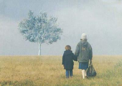 A woman and a child holding hands in a field.