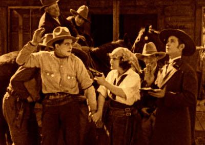 A woman pointing a gun at a man in an Old West setting.