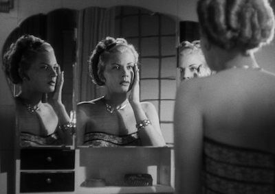 A woman looking at her reflection in a mirror.