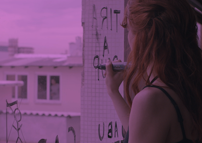 A woman writing on a window.