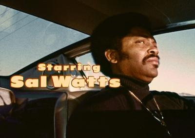 A man driving a car. Title reads: Starring Sal Watts.
